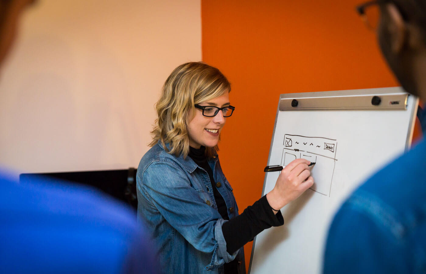 Studio Simpatico UX designer Tamara Olson sketching on whiteboard