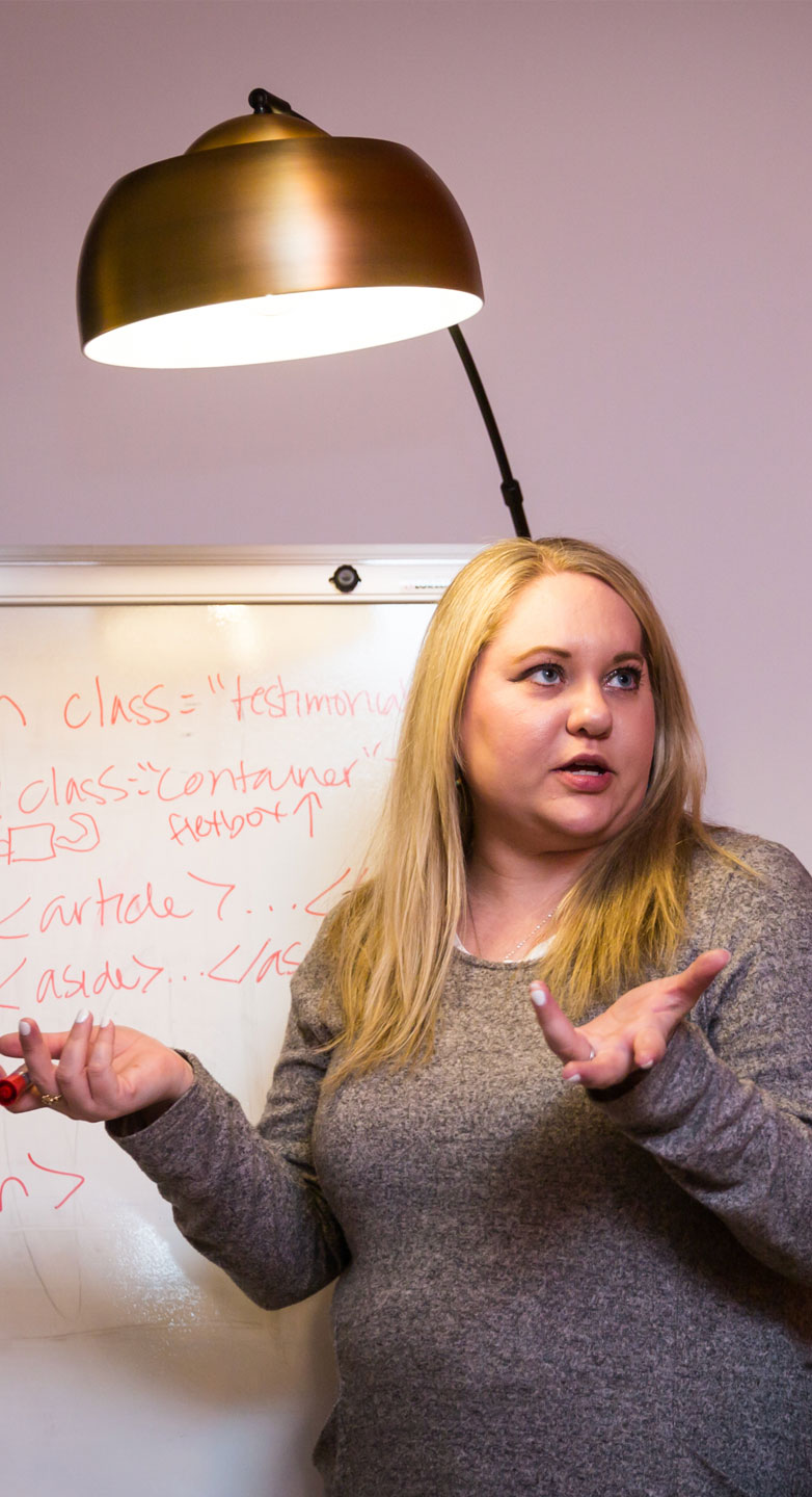 Amber Weinberg writing code on a whiteboard