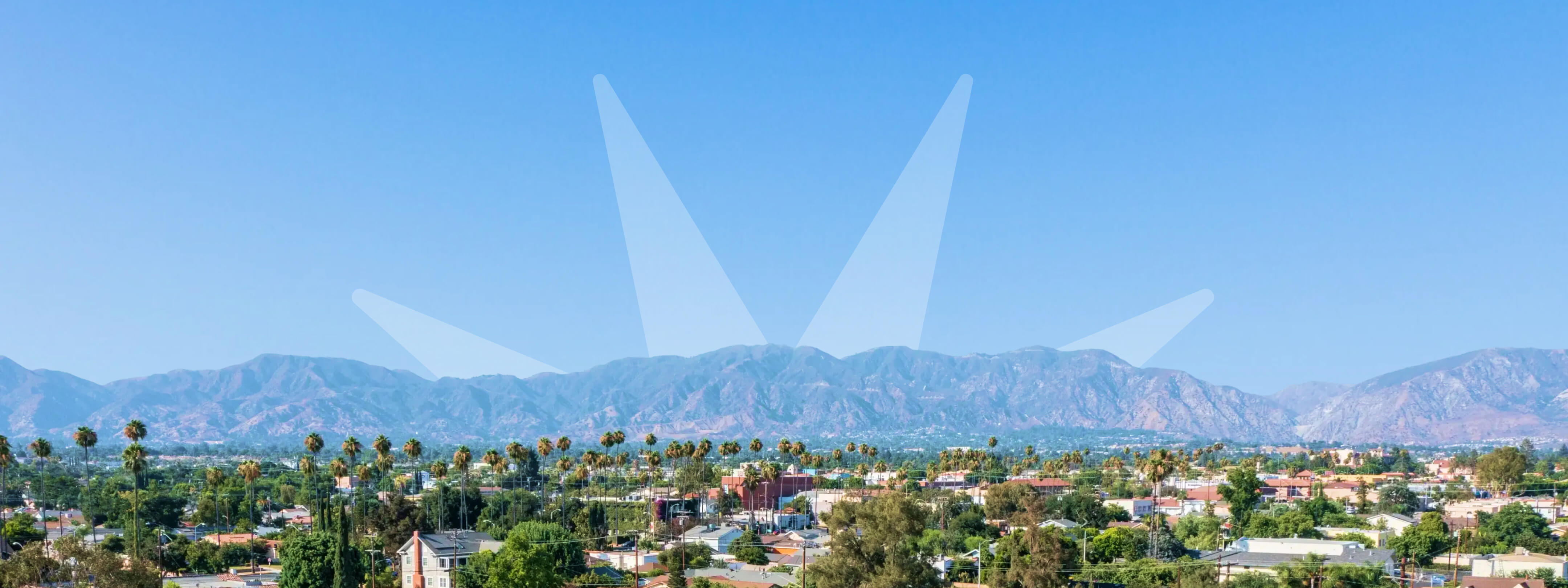 Sunburst logo coming up behind mountains